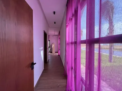 a hallway with pink curtains next to a window at Ferme villa in Skhirat