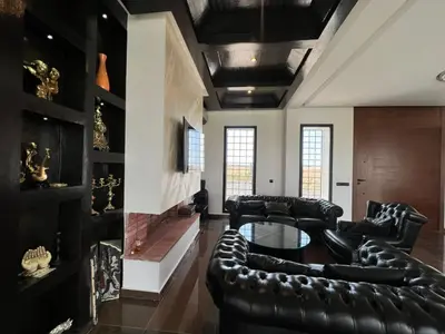 a living room with black leather chairs and a table at Ferme villa in Skhirat