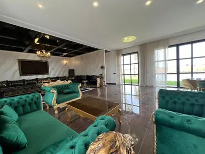 a living room with green couches and a tv at Ferme villa in Skhirat