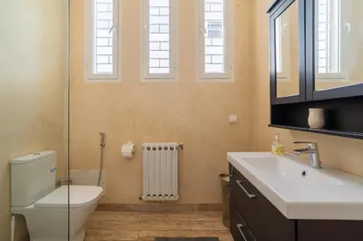 a bathroom with a toilet and a sink and windows at Skhirat Oceanfront Villa 5 Bedrooms Direct Beach Access in Skhirat