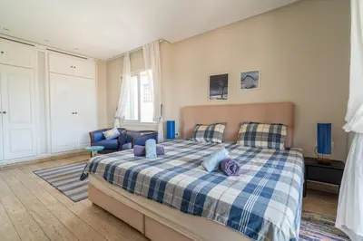 a bedroom with a bed with a blue and white plaid blanket at Skhirat Oceanfront Villa 5 Bedrooms Direct Beach Access in Skhirat