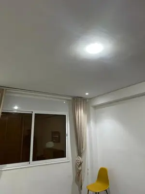 a room with a window and a yellow chair at App 8 in Rabat