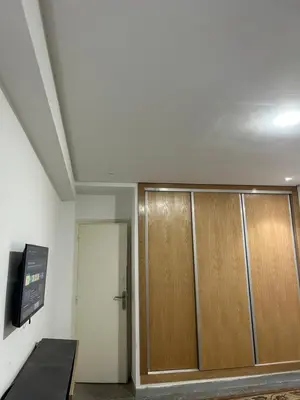 a room with two wooden doors and a tv at App 8 in Rabat