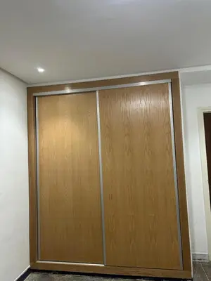 a pair of wooden closet doors in a room at App 8 in Rabat