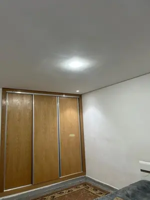a room with wooden doors and a white wall at App 8 in Rabat