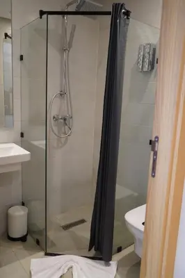 a shower with a glass door in a bathroom at Agdotel Urban Suites in Rabat