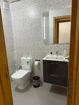 a bathroom with a toilet and a sink and a mirror at Studio Stade Morocco for family in Mohammedia