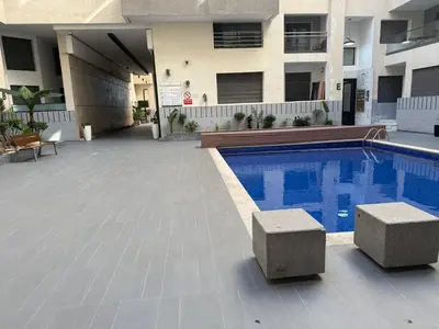 a swimming pool in front of a building at Studio Stade Morocco for family in Mohammedia