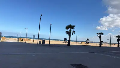 a parking lot next to a beach with palm trees at Studio Stade Morocco for family in Mohammedia