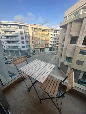 a table and chairs on a balcony with buildings at Luxurious studio for princesses in Casablanca