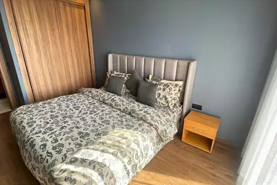 a bedroom with a bed and a night stand at Quiet haven near Sheikh Khalifa Hospital in Casablanca
