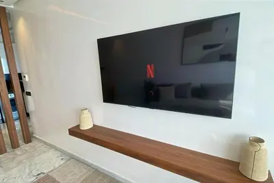 a living room with a large flat screen tv on a wall at Quiet haven near Sheikh Khalifa Hospital in Casablanca