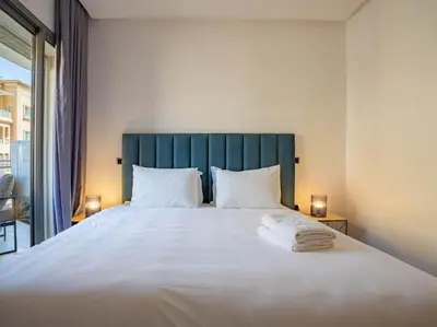 a bedroom with a large white bed with a blue headboard at Travel and Leisure - By AppartAli in Casablanca