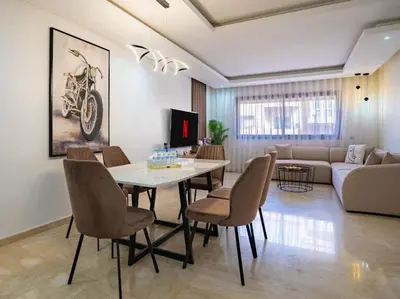 a living room with a table and chairs and a couch at Travel and Leisure - By AppartAli in Casablanca