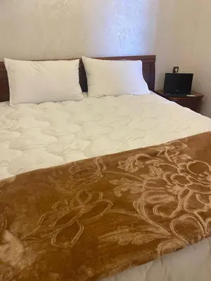 a large bed with a brown and white blanket at Studio moderne avec parking ascenseur -Maarif Centre in Aïn Sebaa