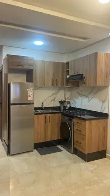 a kitchen with a stainless steel refrigerator and a dishwasher at Studio moderne avec parking ascenseur -Maarif Centre in Aïn Sebaa