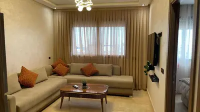 a living room with a couch and a table at Studio moderne avec parking ascenseur -Maarif Centre in Aïn Sebaa