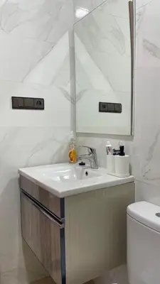 a bathroom with a sink and a mirror and a toilet at Studio moderne avec parking ascenseur -Maarif Centre in Aïn Sebaa