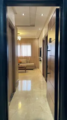 a hallway leading to a living room with a couch at Studio moderne avec parking ascenseur -Maarif Centre in Aïn Sebaa