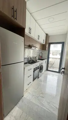 a kitchen with a refrigerator and a stove top oven at Cozy apartment 2 bedrooms 2 bathrooms in Casablanca