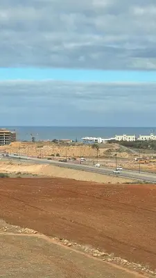 a road in the middle of a desert with the ocean at Cozy apartment 2 bedrooms 2 bathrooms in Casablanca