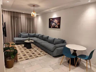a living room with a couch and a table and chairs at Studio Gironde in Casablanca