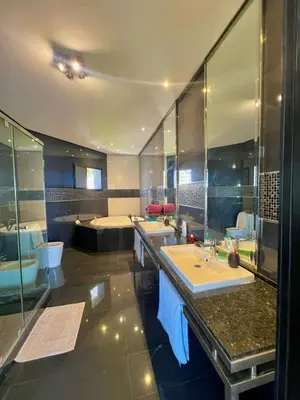 a large bathroom with three sinks and a shower at Waterfront Villa & Private Pool 12 km from the Stadium in Temara