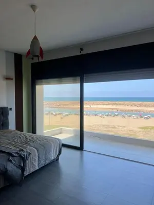 a bedroom with a bed and a large sliding glass window at Waterfront Villa & Private Pool 12 km from the Stadium in Temara