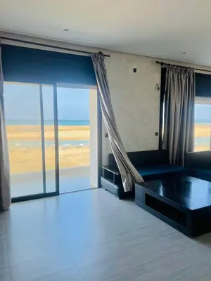 a room with a couch and a view of the beach at Waterfront Villa & Private Pool 12 km from the Stadium in Temara