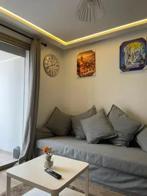 a living room with a couch and a clock on the wall at Stay luxe in Casablanca