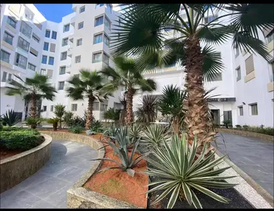 a courtyard with palm trees in front of a building at Stay luxe in Casablanca