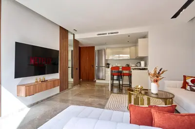 a living room with a white couch and a table at AFCON Casablanca 5 min Walk to Stadium Private Terrace 65 inch TV Fiber Internet All Sports Channels in Casablanca