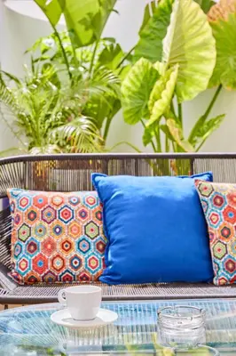 a patio table with pillows and a cup on it at AFCON Casablanca 5 min Walk to Stadium Private Terrace 65 inch TV Fiber Internet All Sports Channels in Casablanca