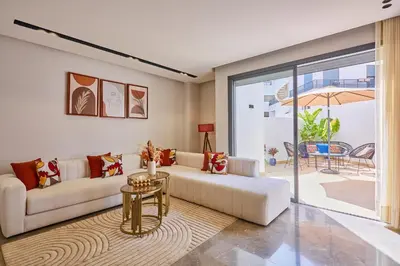 a living room with a couch and a table at AFCON Casablanca 5 min Walk to Stadium Private Terrace 65 inch TV Fiber Internet All Sports Channels in Casablanca