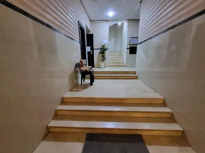 a hallway with stairs with a person sitting on a bench at wbdixmude in Casablanca
