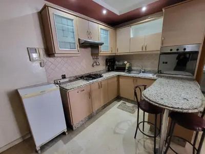 a kitchen with wooden cabinets and a white refrigerator at wbdixmude in Casablanca
