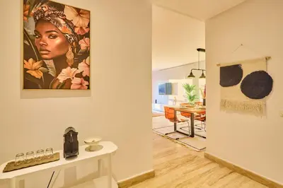 a living room with a painting of a woman on the wall at Oceanfront 2BR by Hassan II Mosque in Casablanca