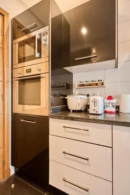 a kitchen with white cabinets and black appliances at Oceanfront 2BR by Hassan II Mosque in Casablanca