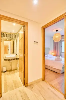 a bedroom with a bed and a bathroom with a mirror at Oceanfront 2BR by Hassan II Mosque in Casablanca