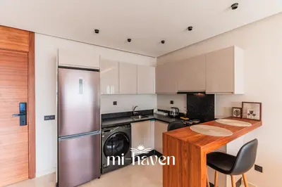 a kitchen with a refrigerator and a table at Aura - 1 BR - Premium Apartment in Maarif