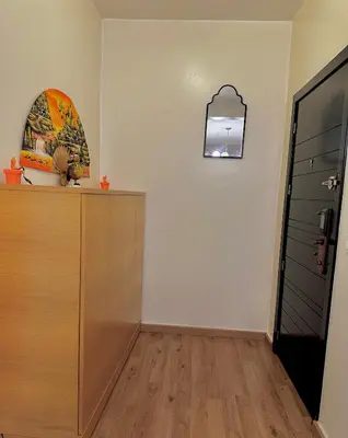 a room with a dresser and a clock on the wall at Cozy appartement Rabat Wifak 5min de Harhoura beach in Temara