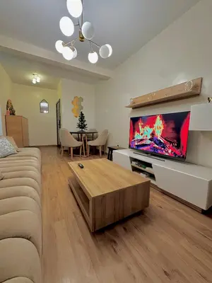 a living room with a couch and a large flat screen tv at Cozy appartement Rabat Wifak 5min de Harhoura beach in Temara
