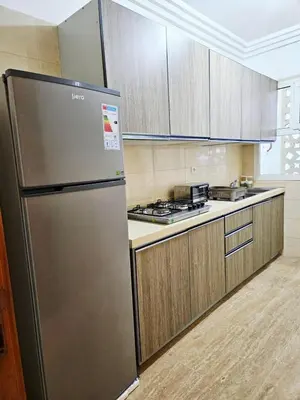 a stainless steel refrigerator in a kitchen with wooden cabinets at Sunset Ocean View in Rabat