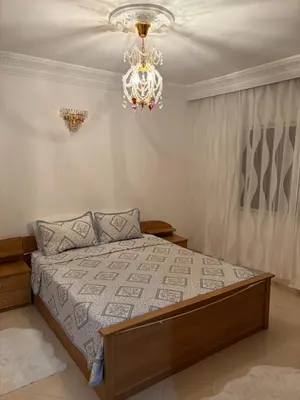 a bedroom with a bed and a chandelier at Harhoura stay à 10min du stade Prince Moulay Abdellah ! in Temara