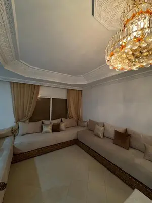 a living room with a couch and a chandelier at Harhoura stay à 10min du stade Prince Moulay Abdellah ! in Temara