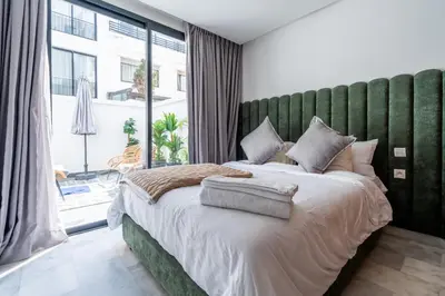 a bedroom with a large bed with a green headboard at 1BR Private Terrace Parking Gym in Casablanca