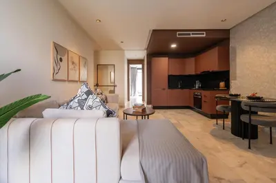 a living room with a white couch and a kitchen at 1BR Private Terrace Parking Gym in Casablanca