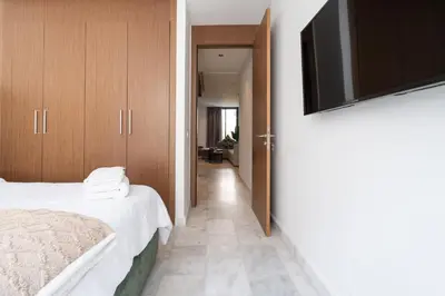 a bedroom with a bed and a flat screen tv at 1BR Private Terrace Parking Gym in Casablanca