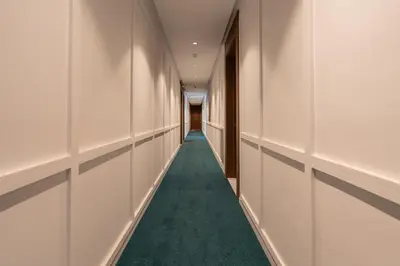 a hallway with white walls and a green carpet at 1BR Private Terrace Parking Gym in Casablanca