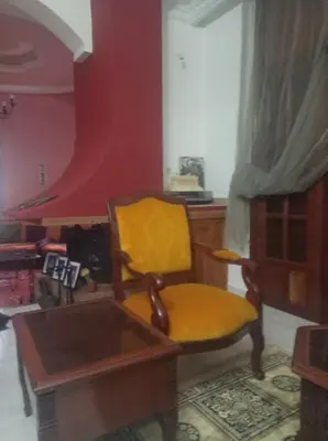 a living room with a yellow chair and a table at 2 bedroom apartment and living room with small terrace in Skhirat